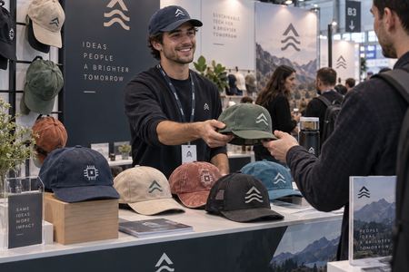 Verteilung bedruckter Baseballcaps an einem Messestand